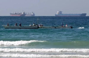 Para nelayan bekerja di depan kapal tanker minyak di selatan Selat Hormuz di lepas pantai kota Ras Al Khaimah di Uni Emirat Arab. (AP Photo/Kamran Jebreili)